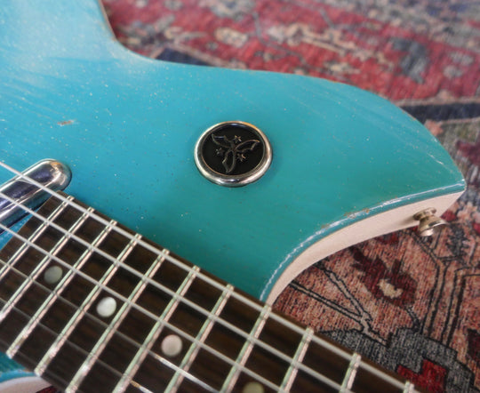 Close-up of the Novo Serus T Taos Turquoise guitar showing the body, fretboard, and logo.