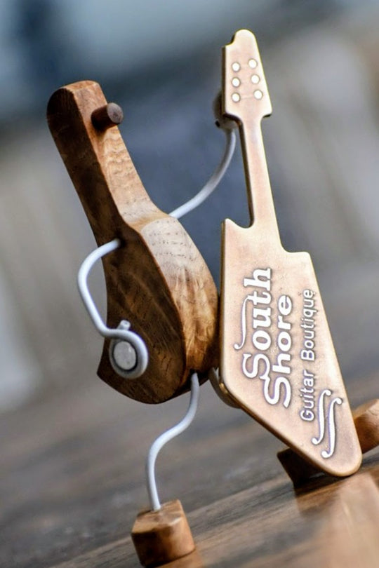 Handcrafted wooden guitar figurine with South Shore Guitar Boutique branding, showcasing artistic design and craftsmanship.